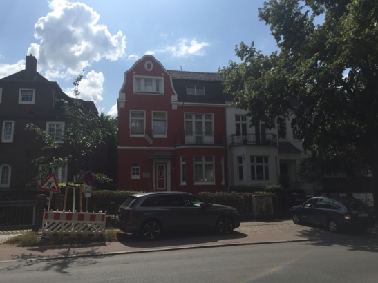 Umgeben vornehmlich unauffälligen Farben sticht ein starkes Rot aus der Masse heraus.